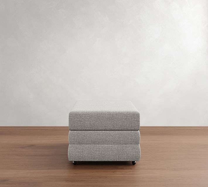 a gray ottoman sitting on top of a wooden floor