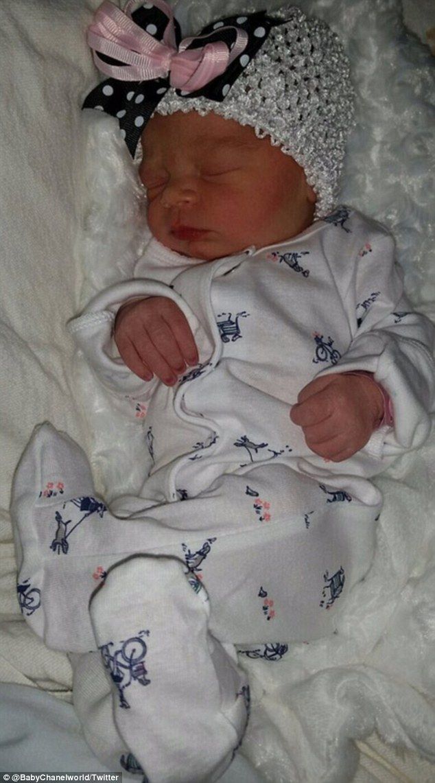 a baby is laying on a white blanket wearing a headband and dress with bows