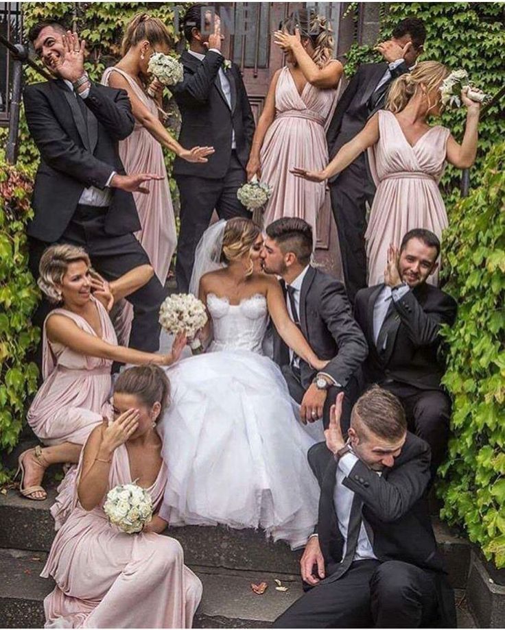 a group of people in formal wear posing for a photo on the steps with their wedding party