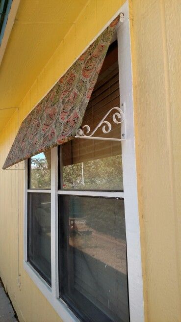 an awning on the side of a yellow building