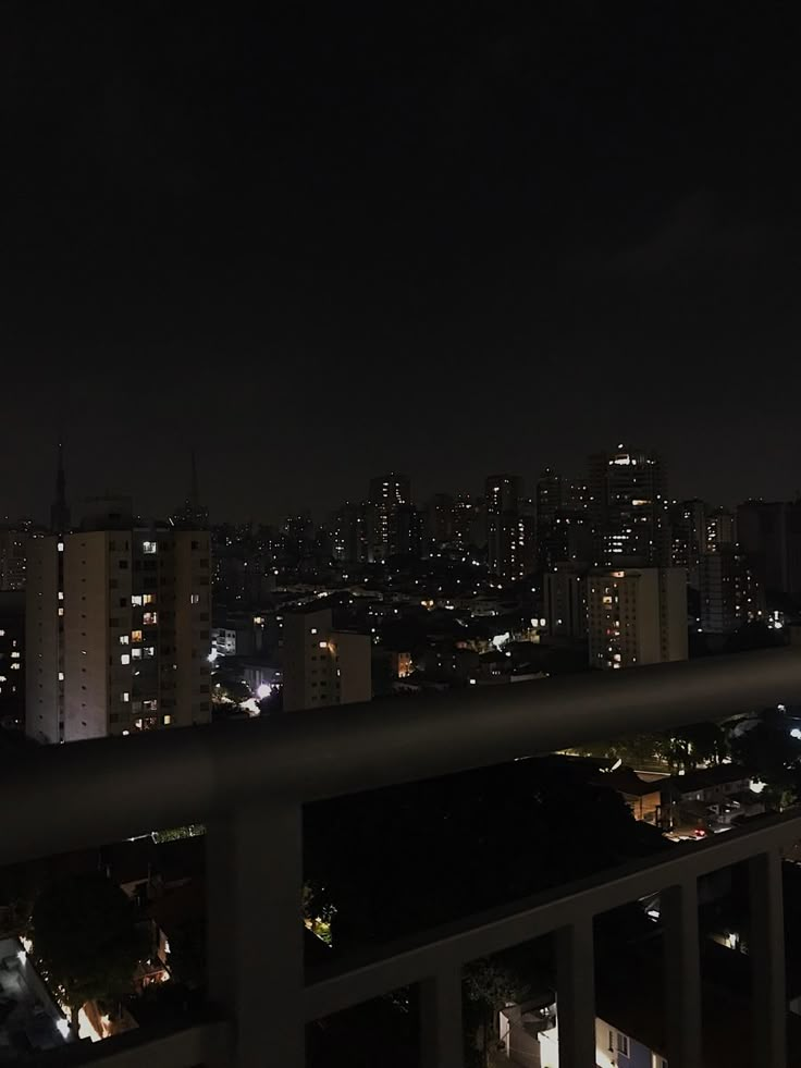 the city is lit up at night and it looks like there are no people on this balcony