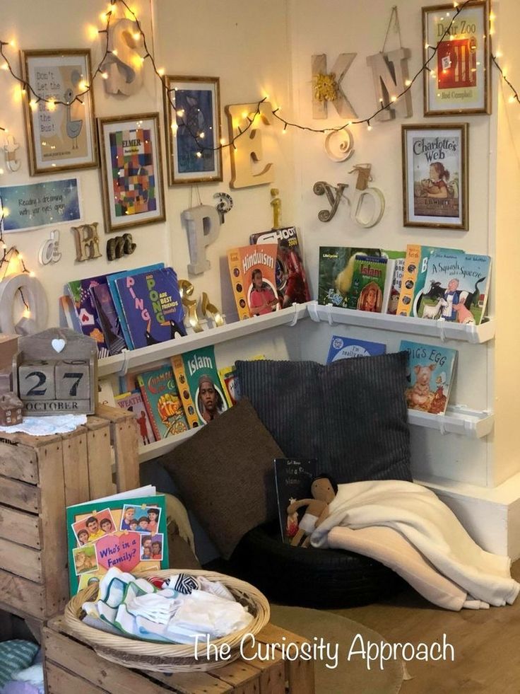 there are many books on the shelves in this children's room with lights strung above them