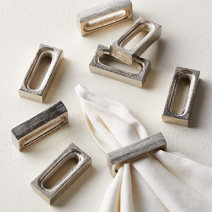 napkin rings and napkin clips on a white surface