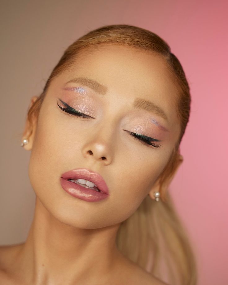 a woman with long blonde hair and blue eyeshadow is posing for the camera