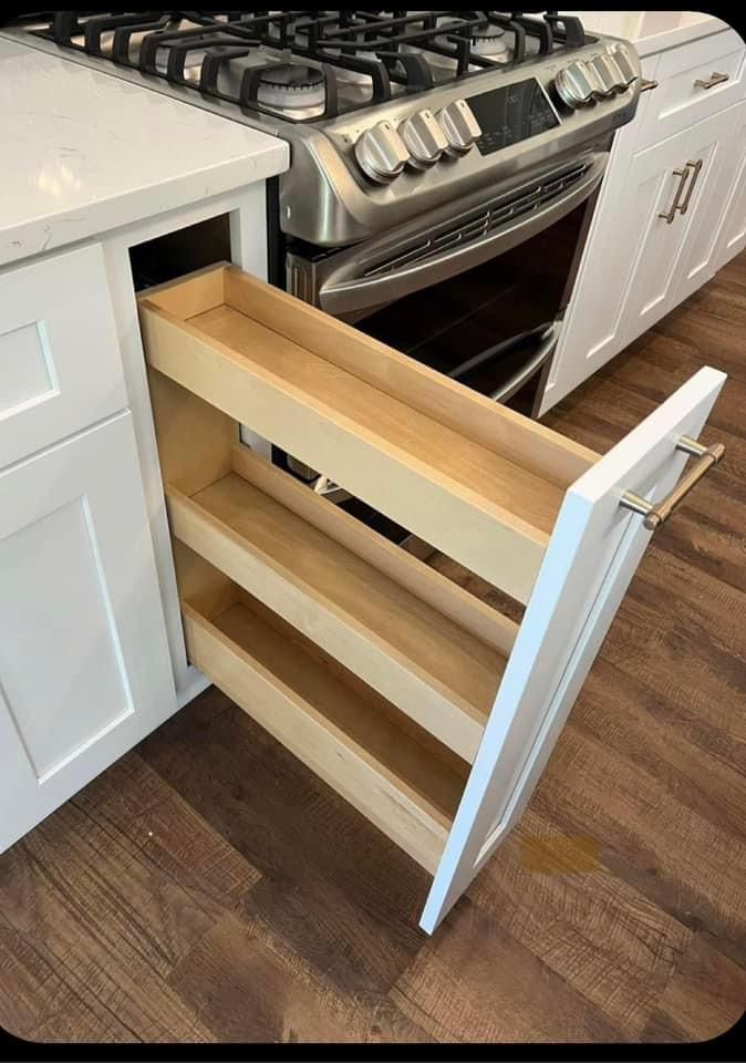 an open drawer in the middle of a kitchen