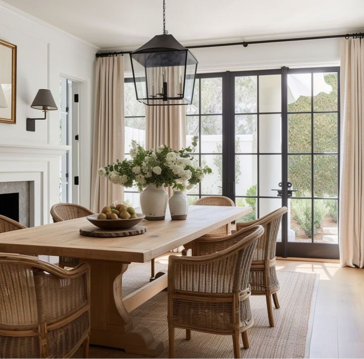 a dining room table with chairs and a bowl of fruit on top of the table