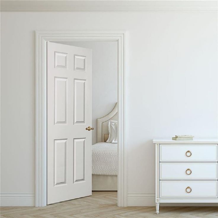 an open door leading to a bedroom with a white bed and dresser in the corner