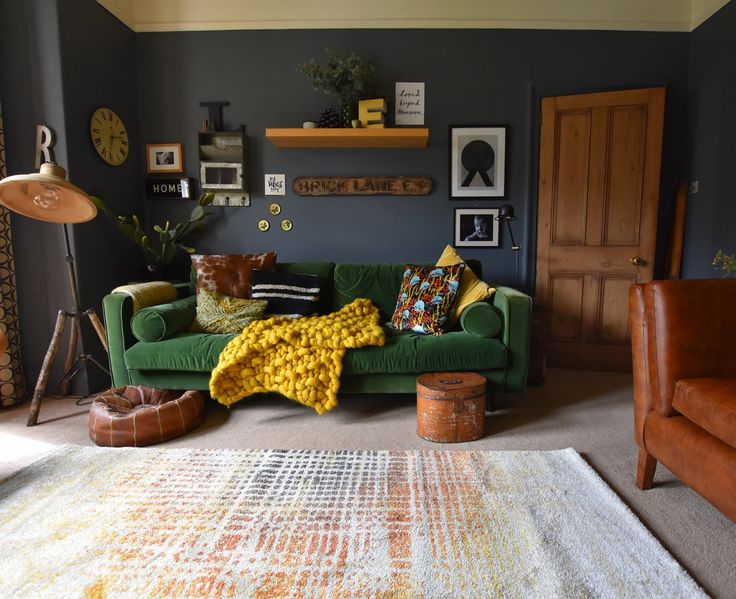 a green couch sitting in a living room on top of a rug next to a chair