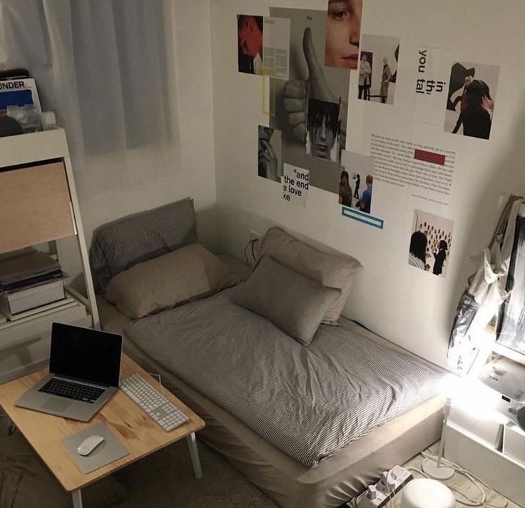 a bed sitting in a bedroom next to a desk with a laptop on top of it