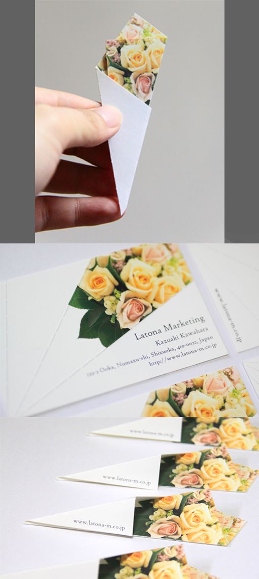 someone is holding up some business cards with flowers on them