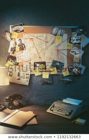 an old typewriter sitting on top of a desk next to a lamp and pictures