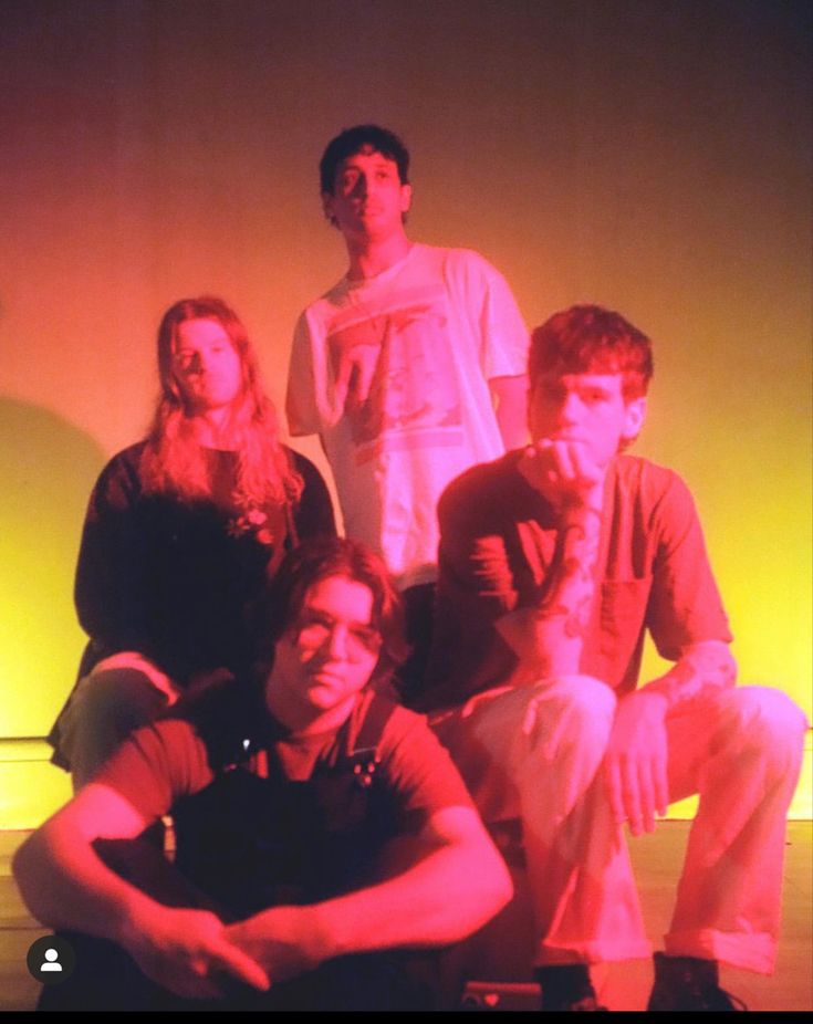 a group of young people sitting next to each other in front of a red light