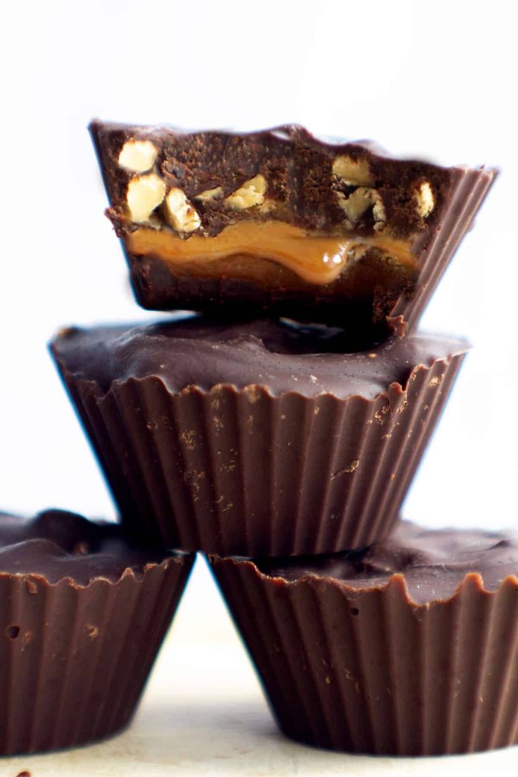 three chocolates stacked on top of each other with peanut butter in the middle and one cut in half