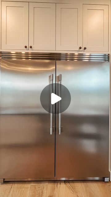 a stainless steel refrigerator in a kitchen with white cabinets and wood flooring, along with an arrow pointing to the left