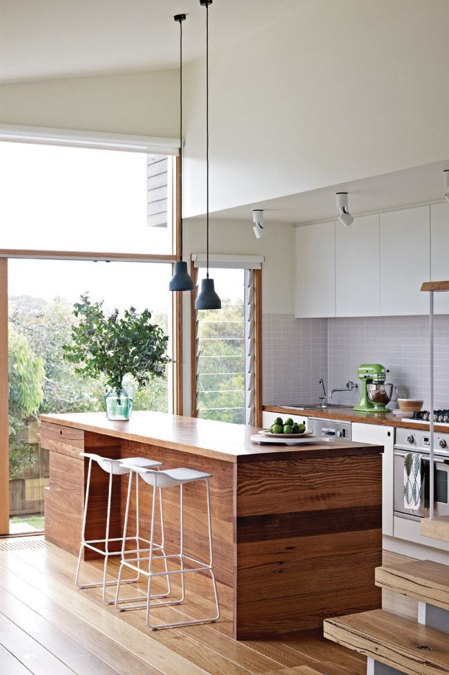 a kitchen with an island and bar stools in it's center room area