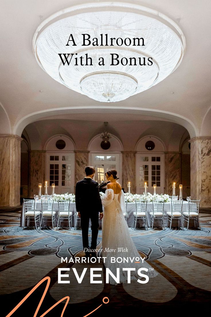 a bride and groom standing in the middle of a room with tables set up for an event