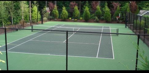 a tennis court surrounded by trees and bushes