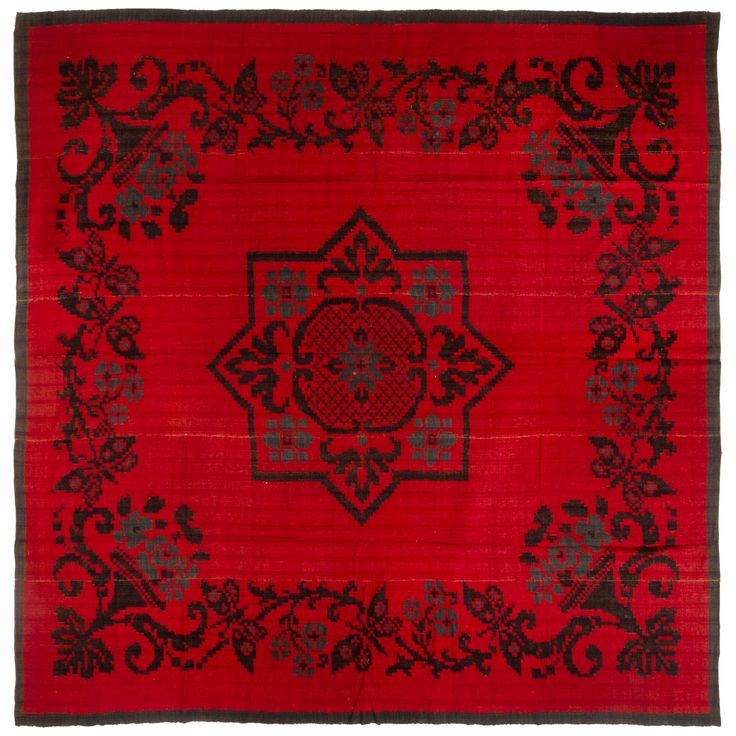 a red rug with black and grey designs on it