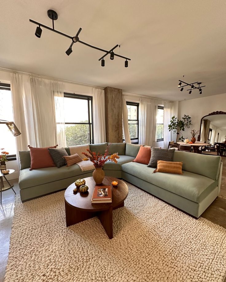 a living room filled with lots of furniture next to a large open floor plan window