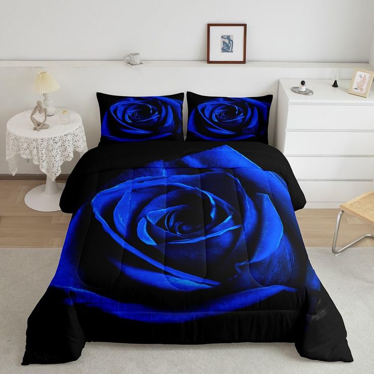 a blue rose is on the bed with black sheets and pillow cases in this room