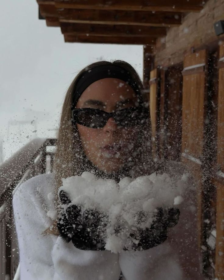 a woman standing in the snow with her hands out