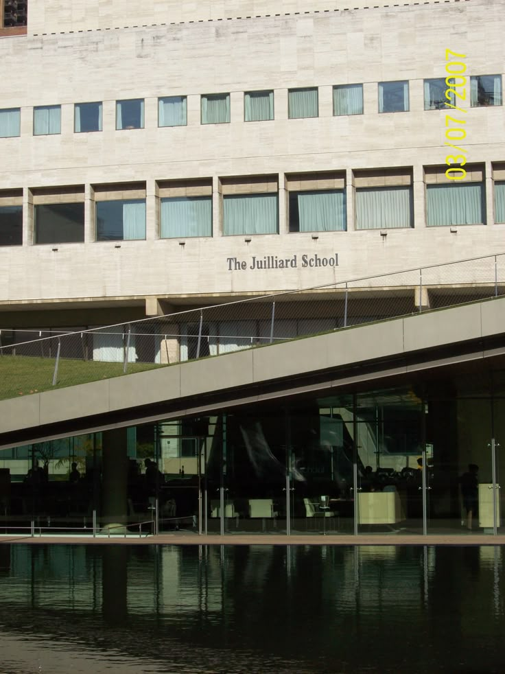 the building has many windows and is next to a body of water in front of it