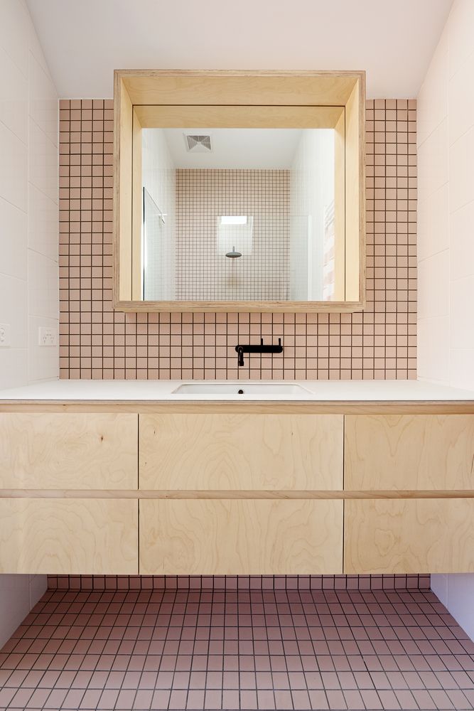 a bathroom with a sink, mirror and tiled flooring in the middle of it