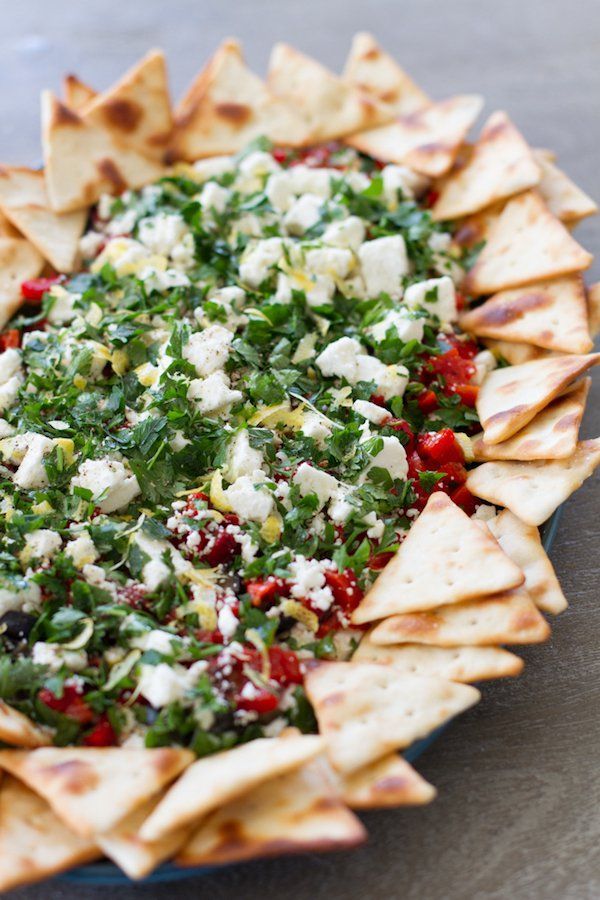 a platter filled with pita bread, cheese and vegetables on top of it