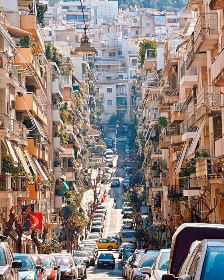 cars are parked on the side of an urban street with balconies and balconies above them