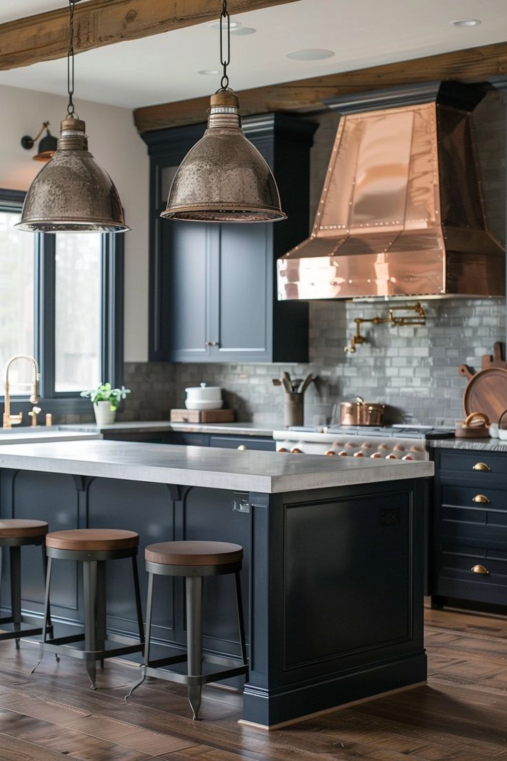 a kitchen with blue cabinets and wooden flooring, two pendant lights hanging over the island