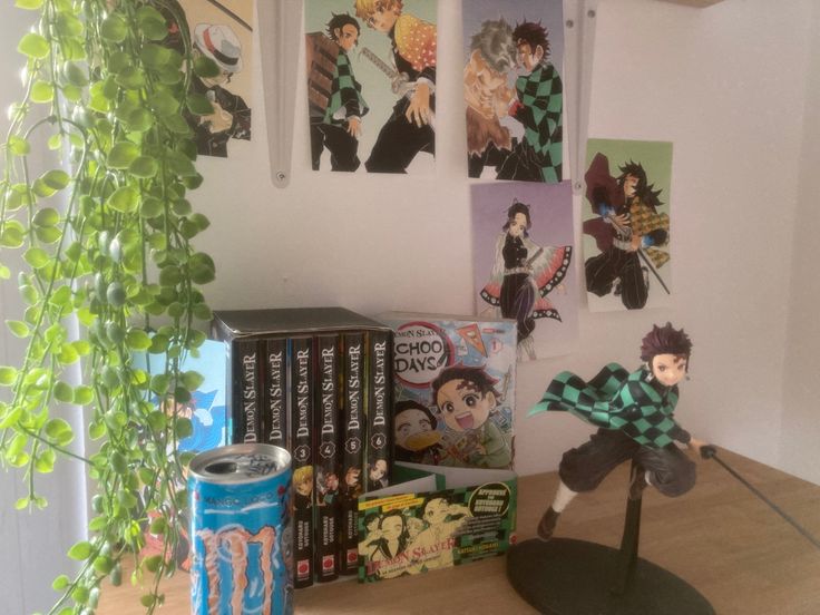 a table topped with books and anime figurines next to a can of soda