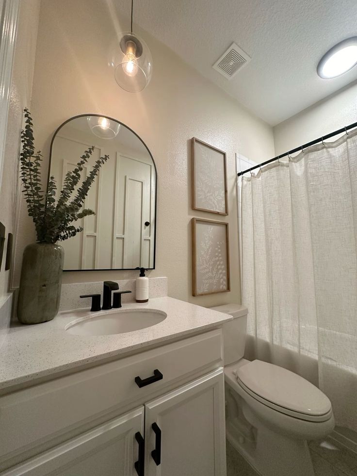 a bathroom with a toilet, sink and mirror in it's centerpieces