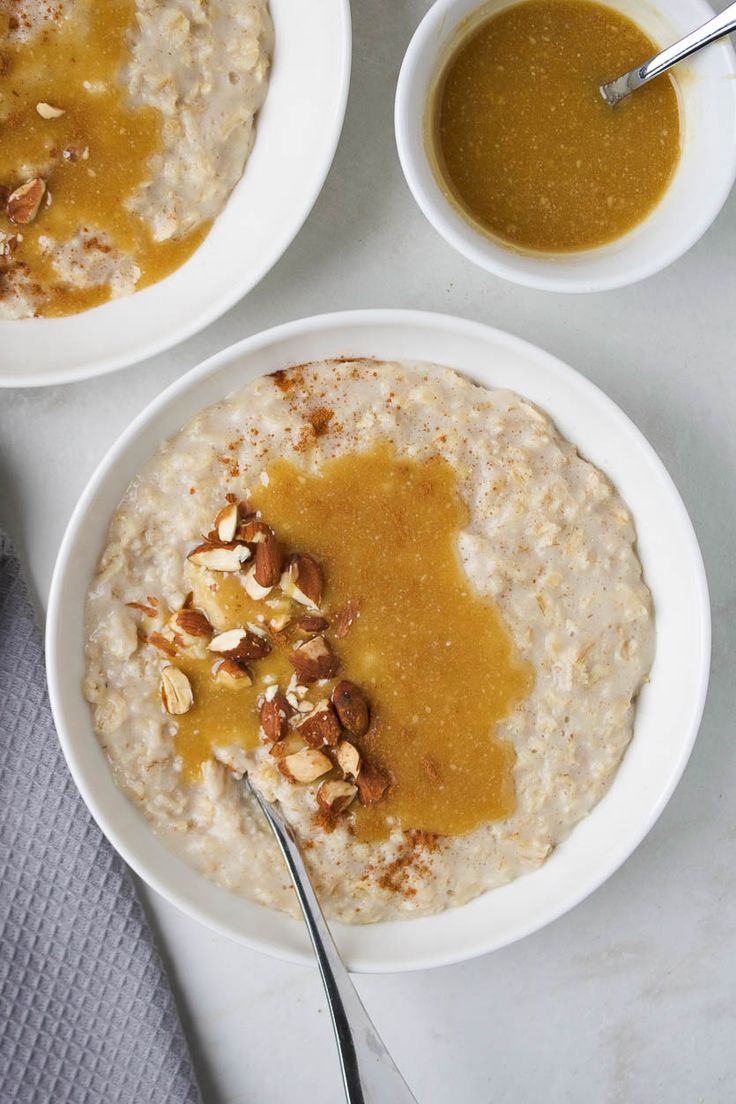 two white bowls filled with oatmeal and nuts