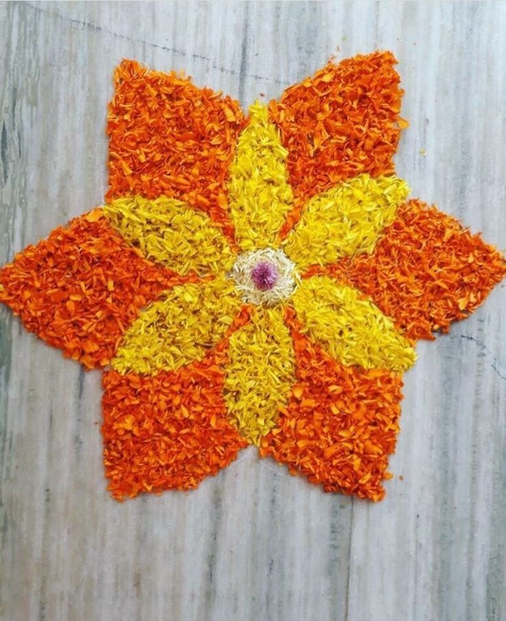 an orange and yellow flower is laying on the ground