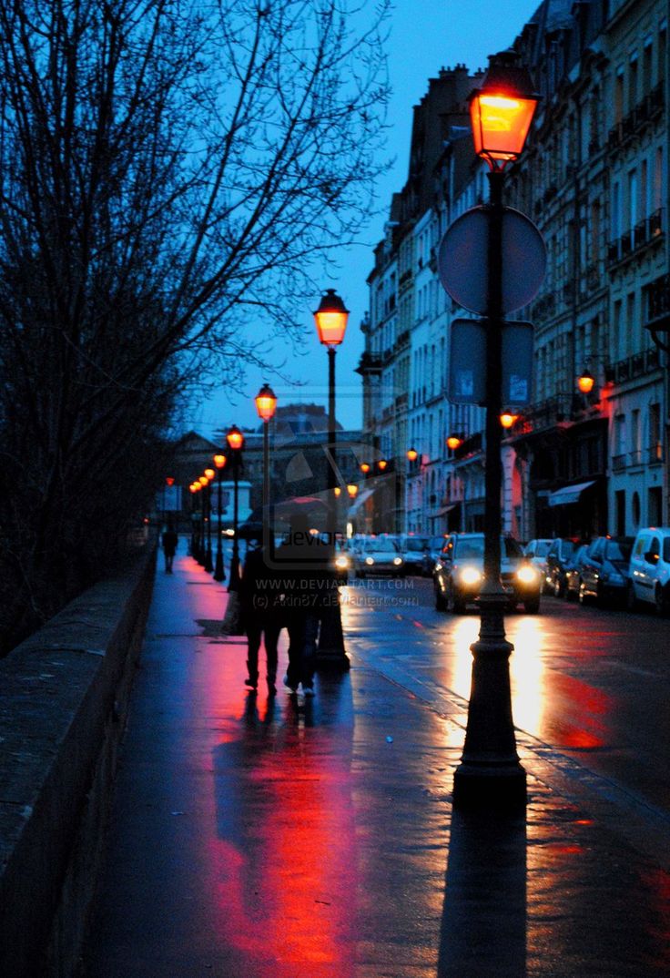 people are walking down the street at night