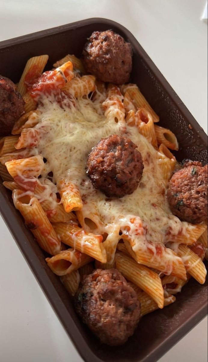 some meatballs and pasta in a pan on a table