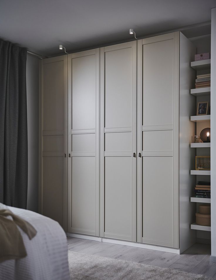 a bedroom with white cupboards and carpeted flooring