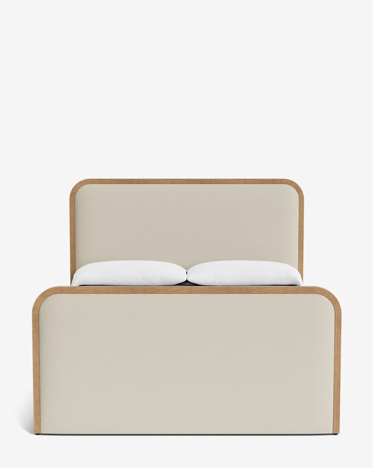 a bed with two pillows on top of it and a wooden frame around the headboard