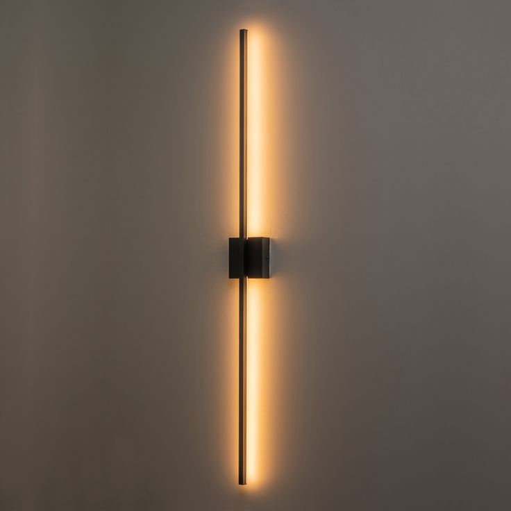 a wall light that is on the side of a wall with a long tube attached to it