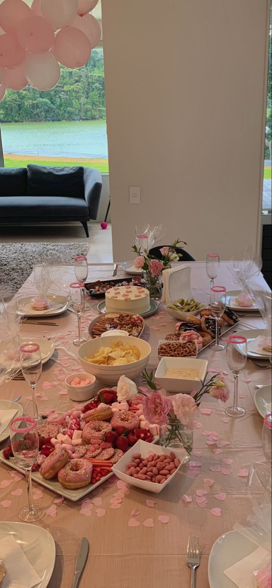 the table is set with desserts and balloons