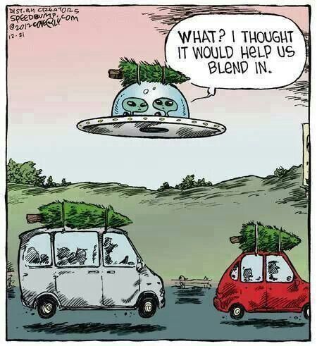 a car with a christmas tree on the roof is driving past an alien flying saucer