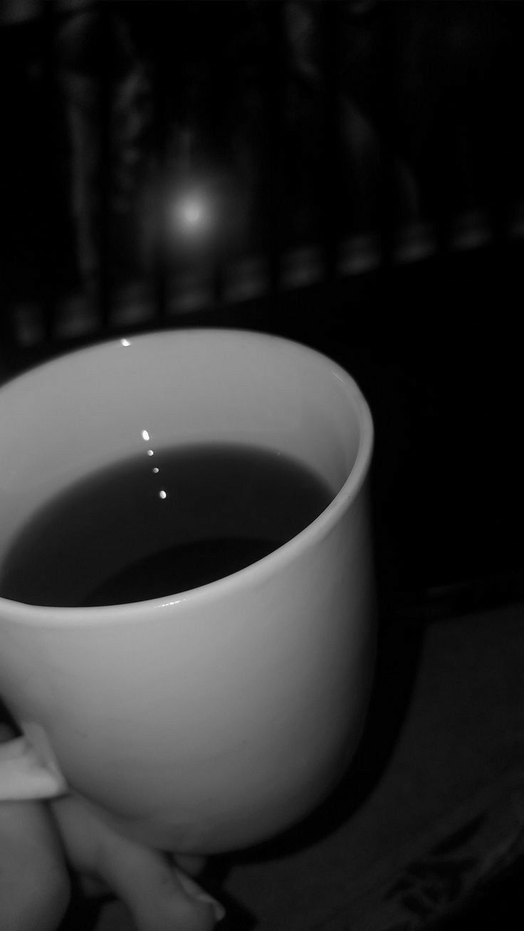 a cup of black tea sitting on top of a table