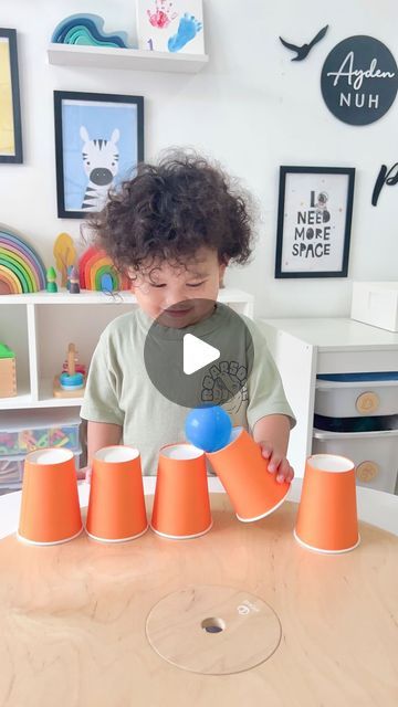 a young child playing with orange cones on a table