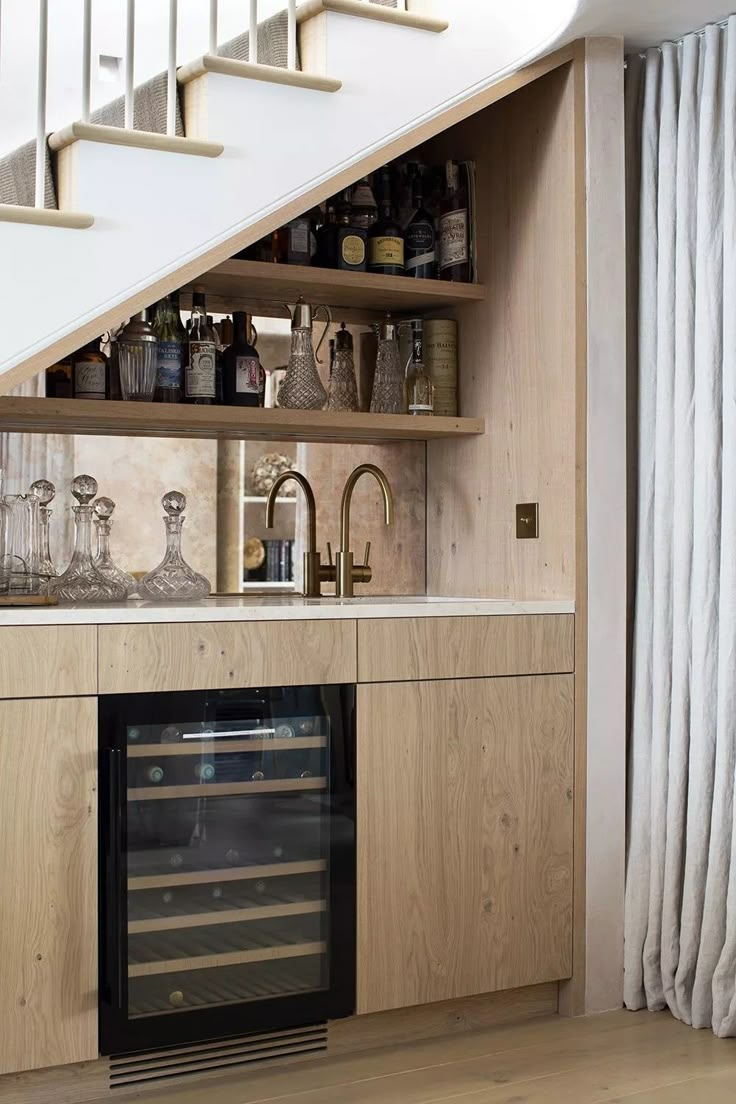 a kitchen with an oven, wine rack and stairs in the backround area