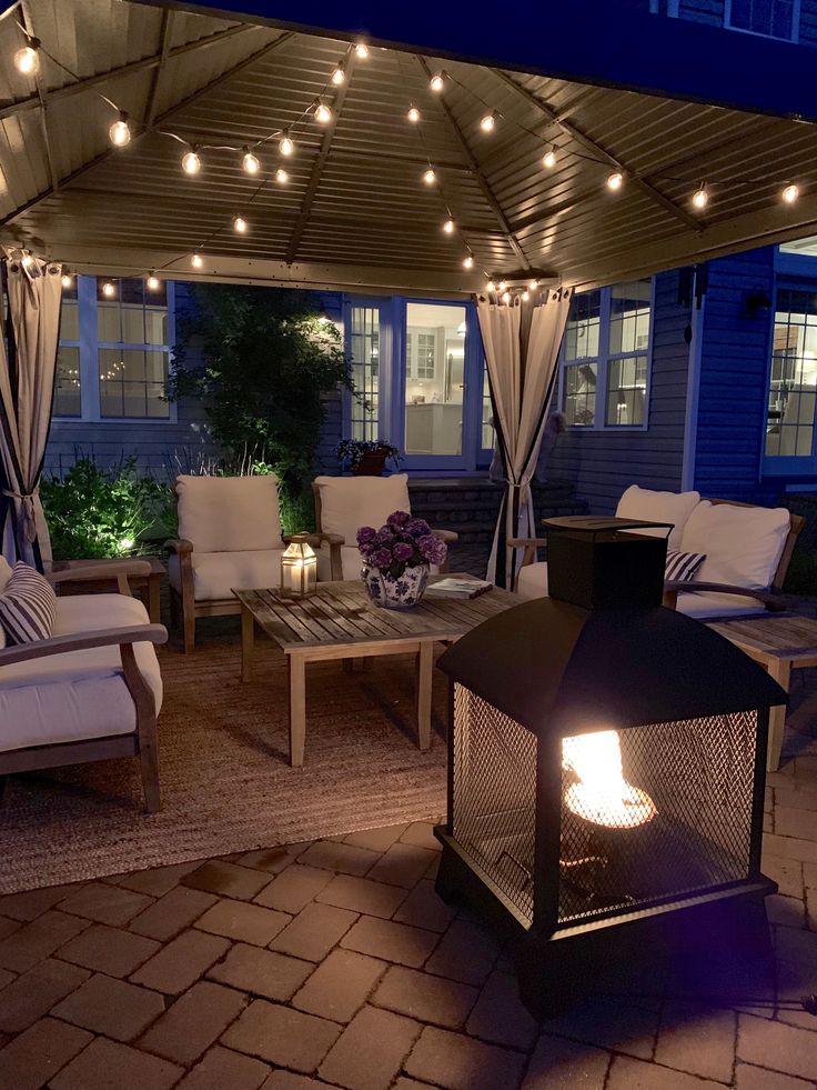 an outdoor living area with patio furniture and string lights on the pergolated roof