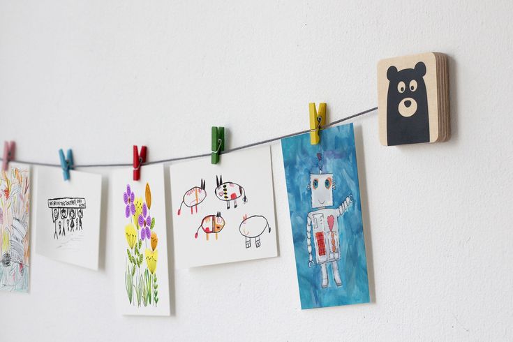 children's artwork hangs on a clothes line