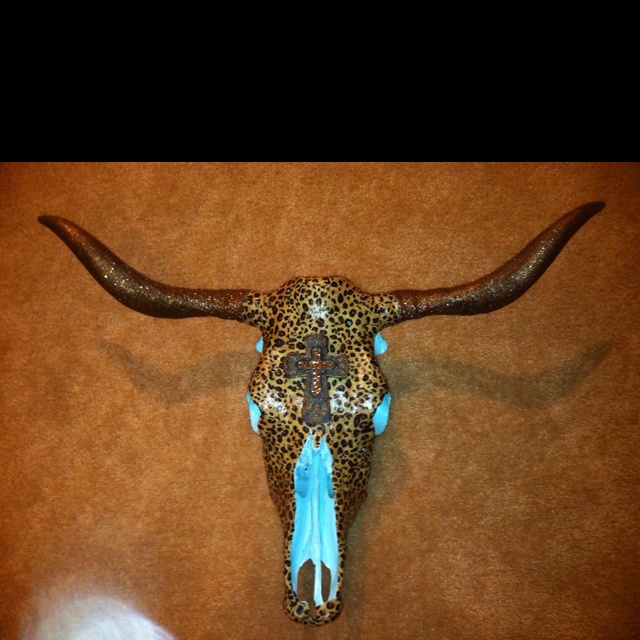 an animal's skull is adorned with blue beads and leopard print on the wall