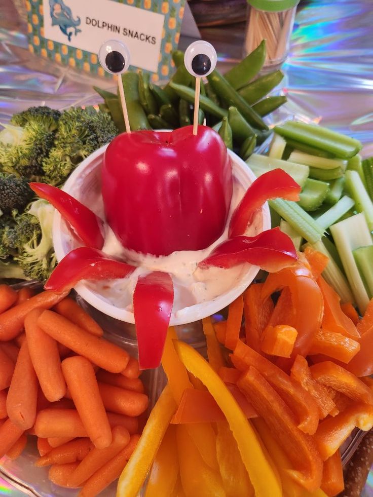 an assortment of veggies and dips are arranged on a platter for a child's birthday party