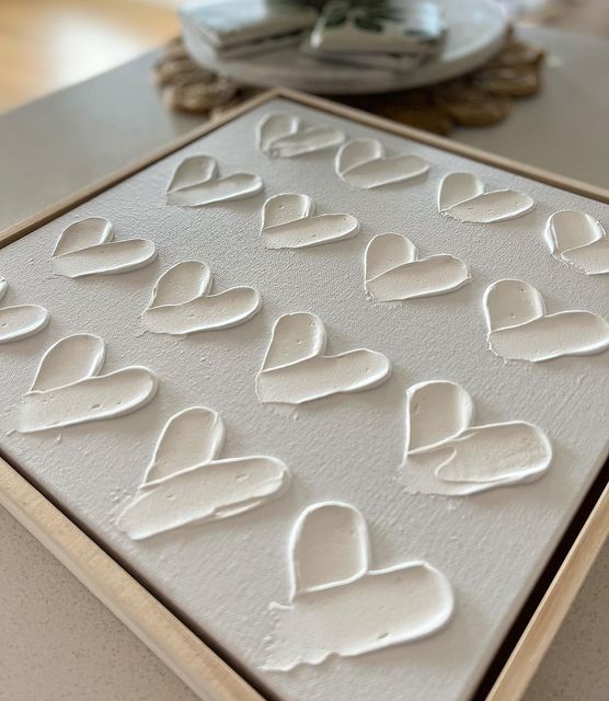 a cookie sheet with white frosting in the shape of hearts on top of it