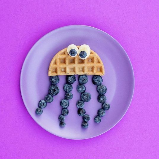 a plate topped with waffles and blueberries covered in googly eyeballs